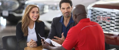 Compradores de autos nuevos haciéndole preguntas al concesionario