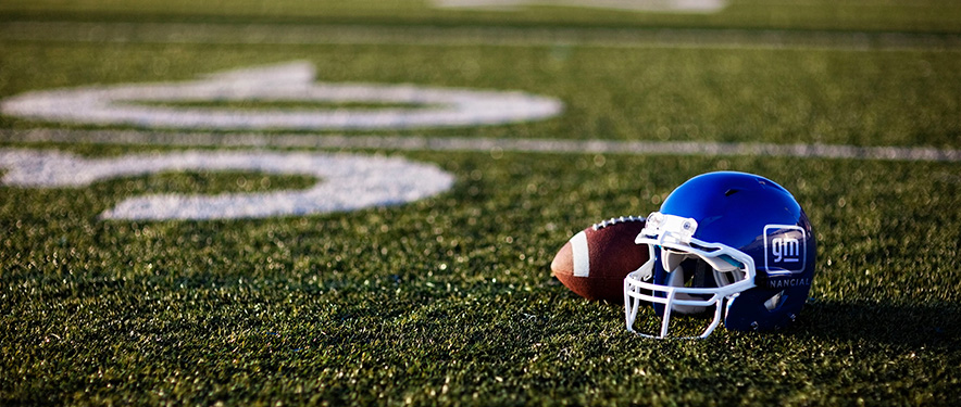 El fútbol americano y el casco azul de GM Financial en un campo de fútbol