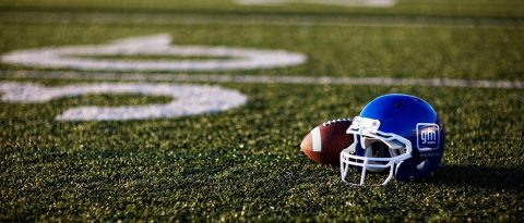 El fútbol americano y el casco azul de GM Financial en un campo de fútbol