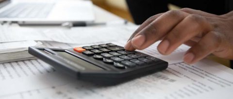 Close-up of person using calculator to work on budget
