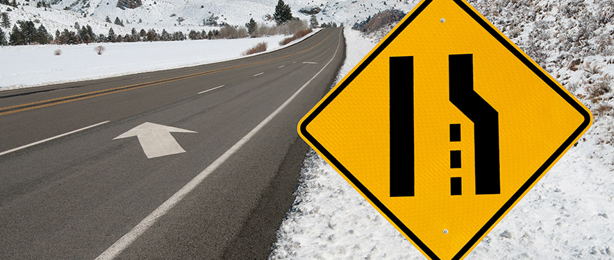 Combinar el letrero izquierdo en una carretera de montaña invernal