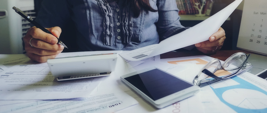 Cluttered table view of someone doing taxes.